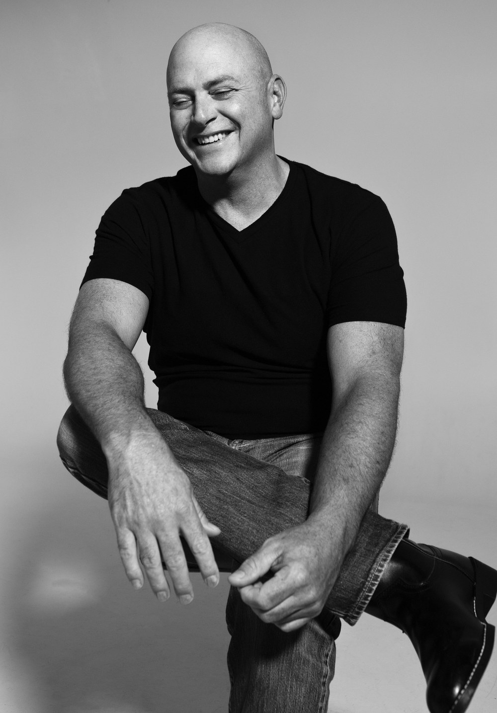 Murphy O'Neal — black-and-white studio portrait, smiling, seated with crossed legs